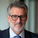 Retrato de Javier G., un hombre de 50s con una sonrisa confiada y saludable.